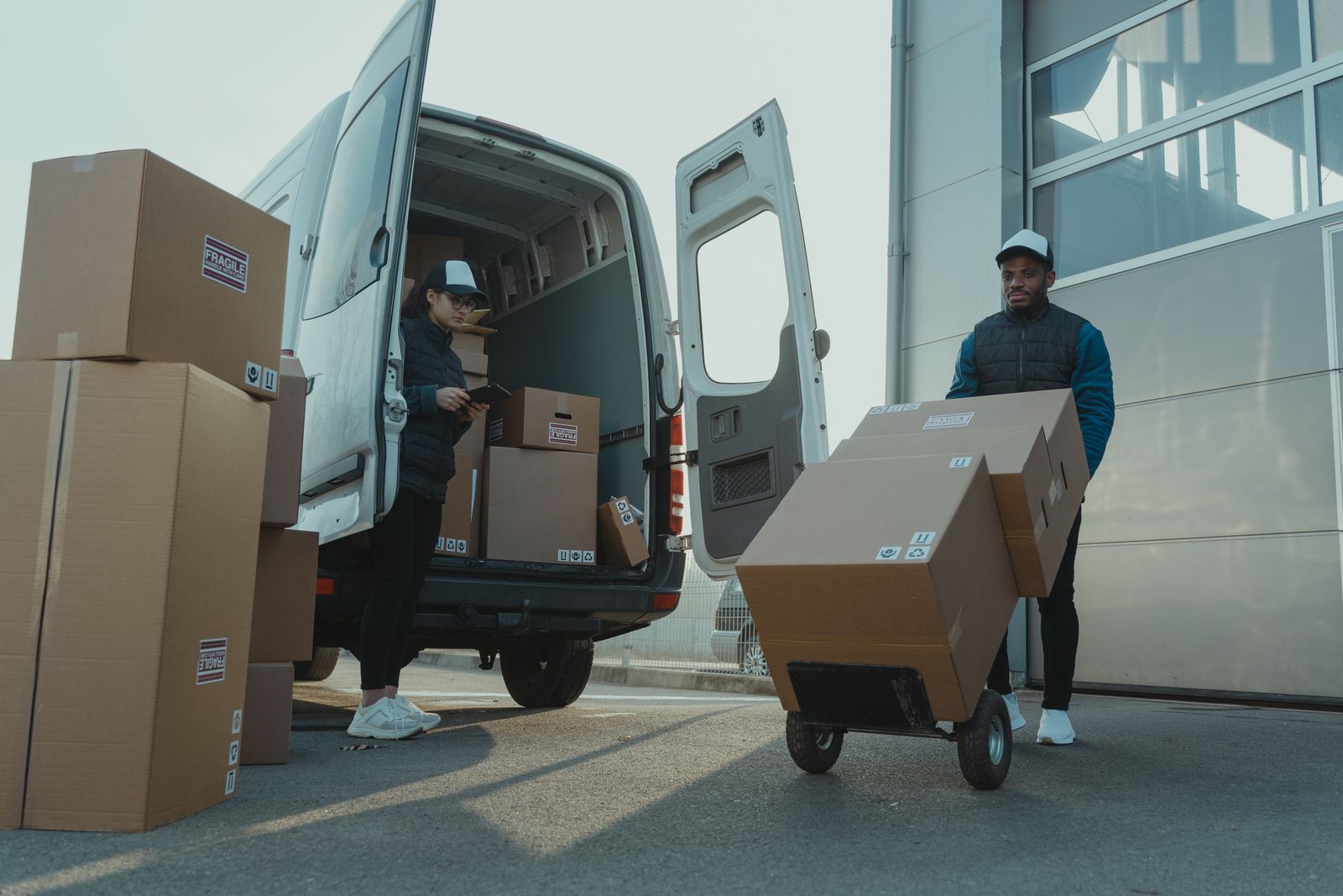 Two small business owners loading boxes from their delivery van